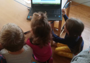 Dzieci oglądają na laptopie prezentację o Europejskim Centrum Bajki w Pacanowie.